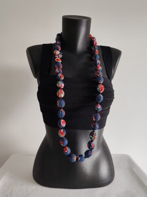 Collier sautoir modulable en perles de coton fleuri rouge et blanc sur fond bleu marine