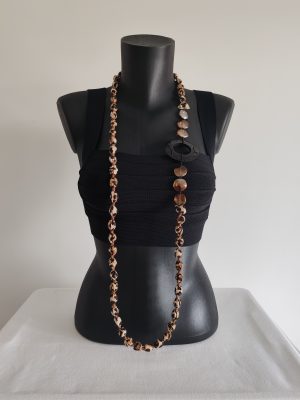Collier sautoir en perles de coton motifs léopard, avec perles de verre irisées et bois sculpté porté long sur un buste noir