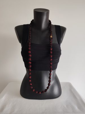 Collier sautoir Naïla en taffetas rouge bordeaux, présenté simple, fermoir devant sur un buste noir
