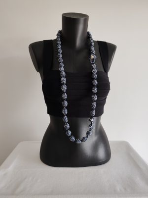 Collier sautoir Naïla en tissu bleu marine à pois blancs, présenté sur un buste noir