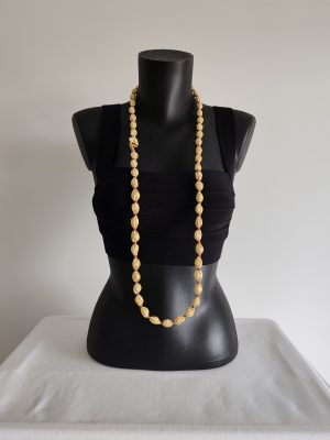Collier sautoir Naïla en taffetas de soie jaune clair et fil de coton doré, présenté simple sur un buste noir