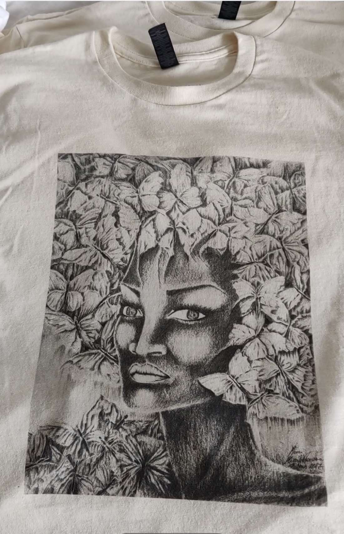 T-shirt en heavy cotton, écru, avec un portrait de femme noire aux cheveux papillons stylisés en coupe afro